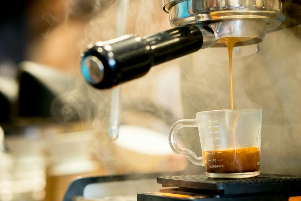 a cup of coffee being filled with liquid